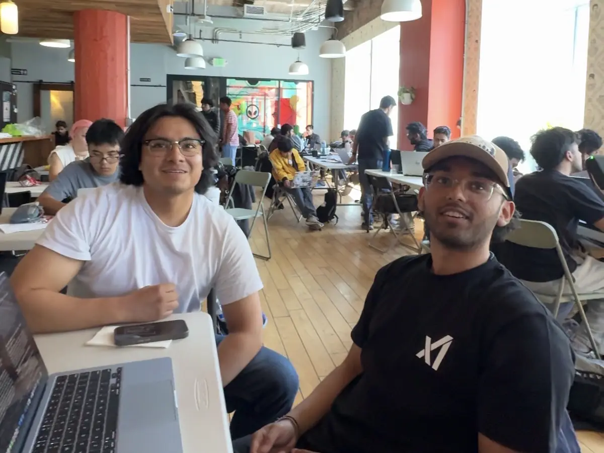 Two builders at their table mid-hackathon